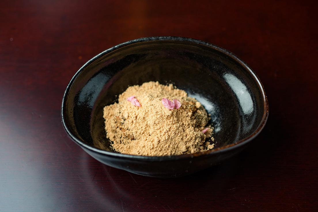 本蕨粉を練り上げ、仕上げに黒蜜を練り込んだ「蕨もち」。たっぷりの深煎りきな粉、桜塩漬け。季節に合わせて温度や形を変えて提供される。