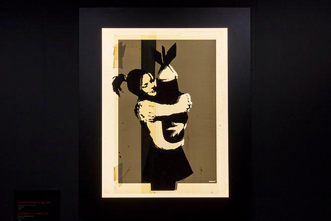 《PRINTING PLATE BOMB LOVE》（2003）爆弾を抱える少女を描いたステンシル作品《BOMB LOVE》の、貴重なオリジナルプレート。無邪気さと純粋さ、戦争の恐ろしさを象徴する作品。