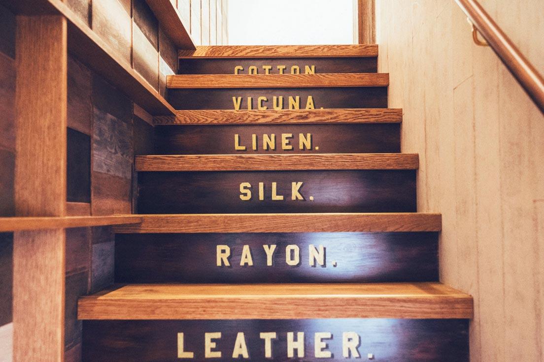 階段には〈Porter Classic〉の衣類や鞄に使われる素材の名前がハンドペイントされている。