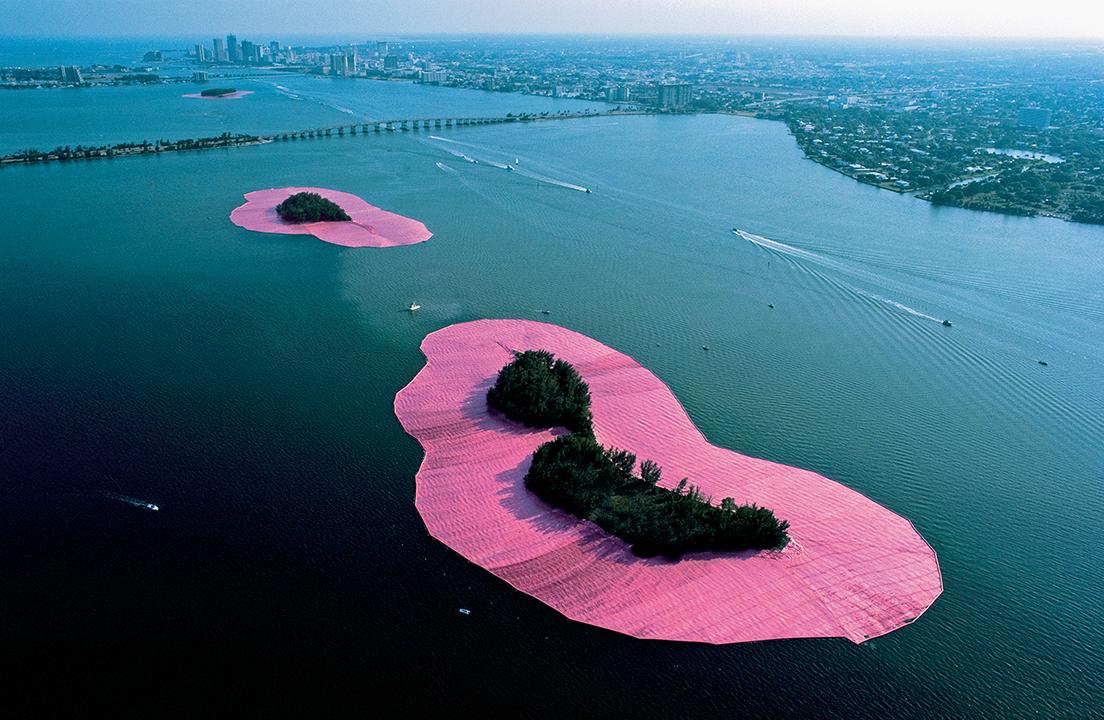フロリダ、ビスケーン湾の11の島を計650万平米に及ぶピンクの布で囲んだ《囲まれた島》（1983）　Photo: Wolfgang Volz © 1995 Christo 
