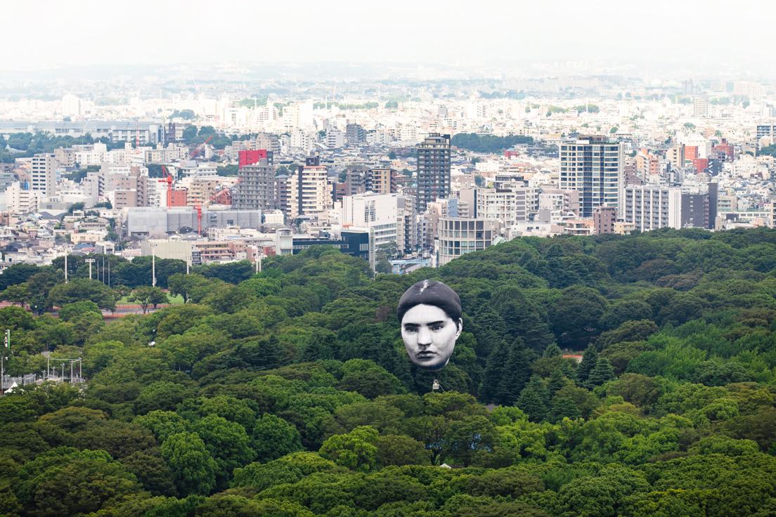世界中から募った一般人の顔から「実在する一人の顔」が浮かんでいる。東京の景色と同化させるためあえてモノクロで制作された。