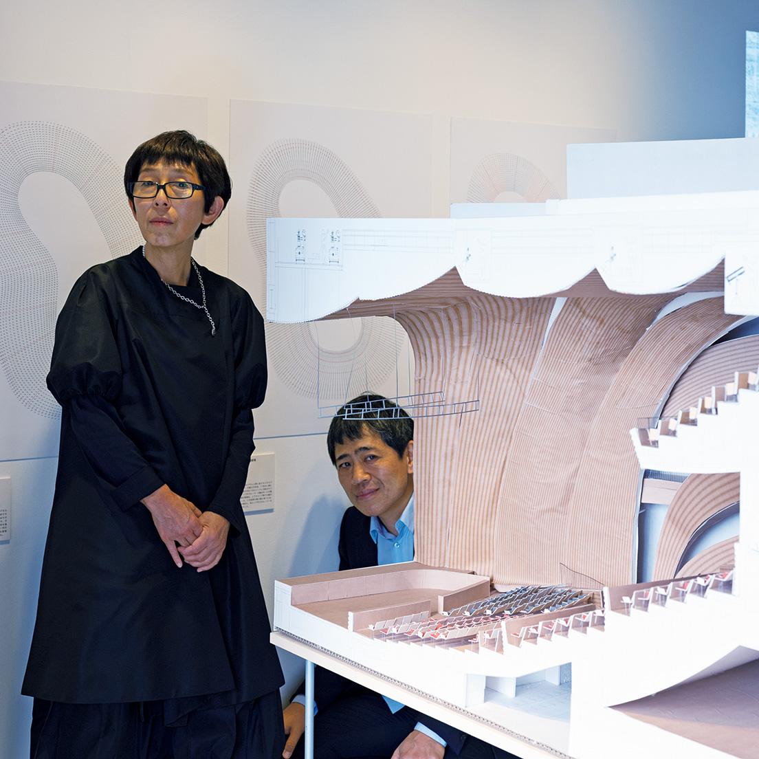 〈蘇州獅子山広場芸術劇場〉の模型のそばで。展示されている模型は、基本的に実際に事務所でも使っているもの。二人の設計のプロセスをリアルに体感できる展示だ。撮影・ホンマタカシ。photo_Takashi Homma