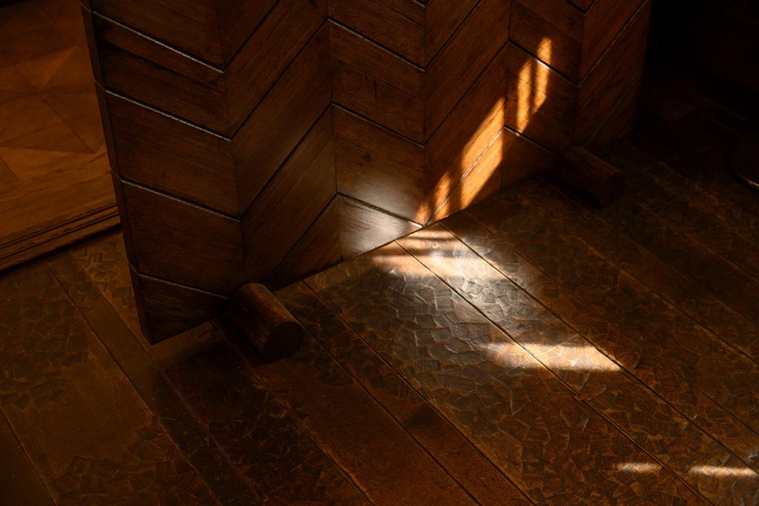 「聴松閣」1階・旧食堂の床。手斧（ちょうな）を用いた「名栗（なぐり）仕上げ」で、無垢床材に彫りを入れている。