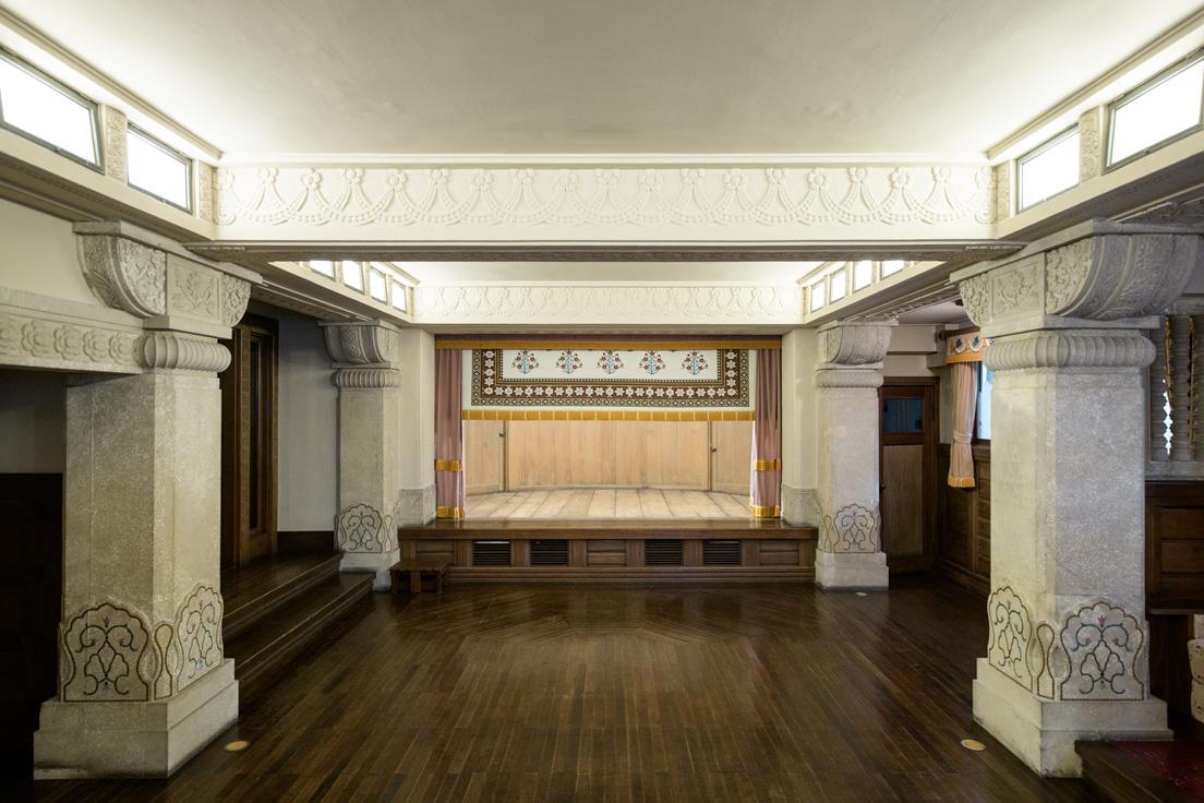 能や狂言で使われていたという「聴松閣」地下・旧舞踏場の半円型の舞台。右側の小さな扉は切戸口で、演者は身をかがめて登場する。