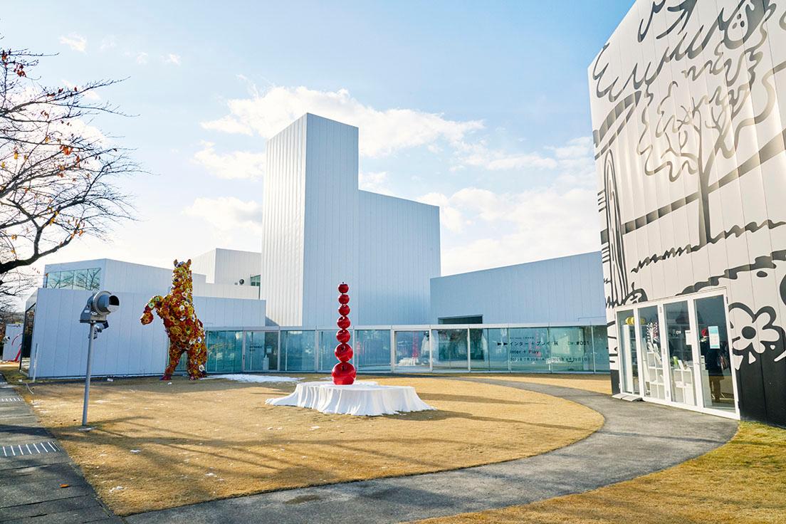 開館10周年を迎えた〈十和田市現代美術館〉。左奥はチェ・ジョンファ《フラワー・ホース》。中央は鈴木康之《はじまりの果実》。