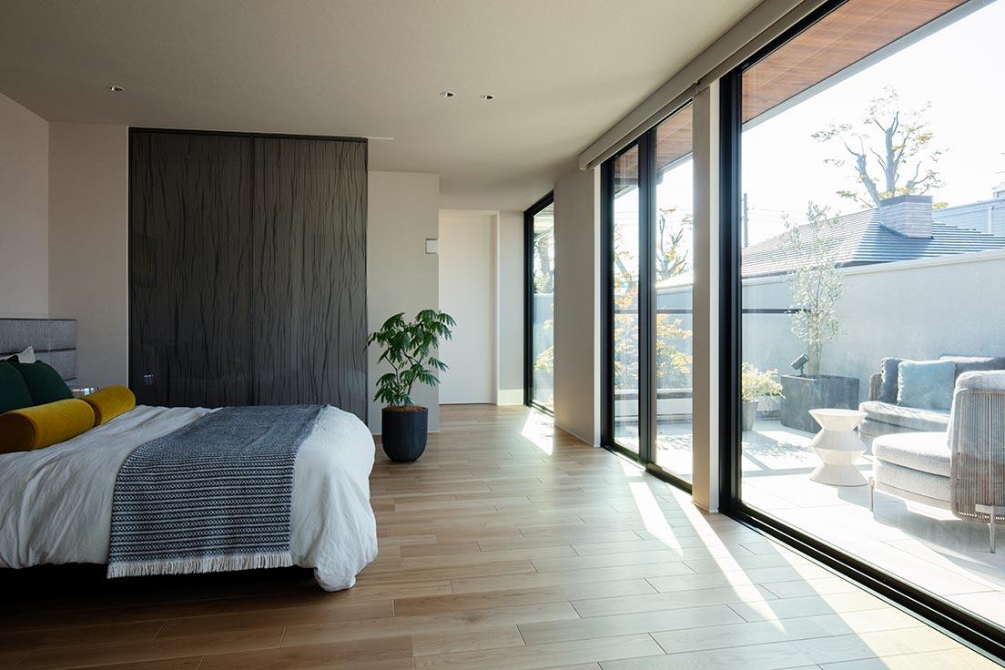 〈シャーウッド〉のベッドルーム例。
木のフローリングが温かみを感じさせる寝室。屋内外の天井面と床面の高さを揃え、室内外をシームレスにつなぐ。屋外の気持ちよさを室内に取り込む縁側の様なスタイル。
