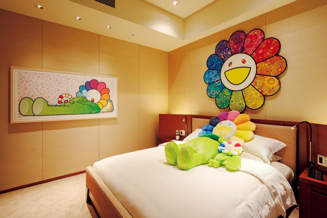 お花尽くしのベッドルーム。壁の作品は《お花の森》（右）と《Zzz》（左）。一緒に添い寝ができちゃう180cmサイズのお花の親子のぬいぐるみがベッドに♡