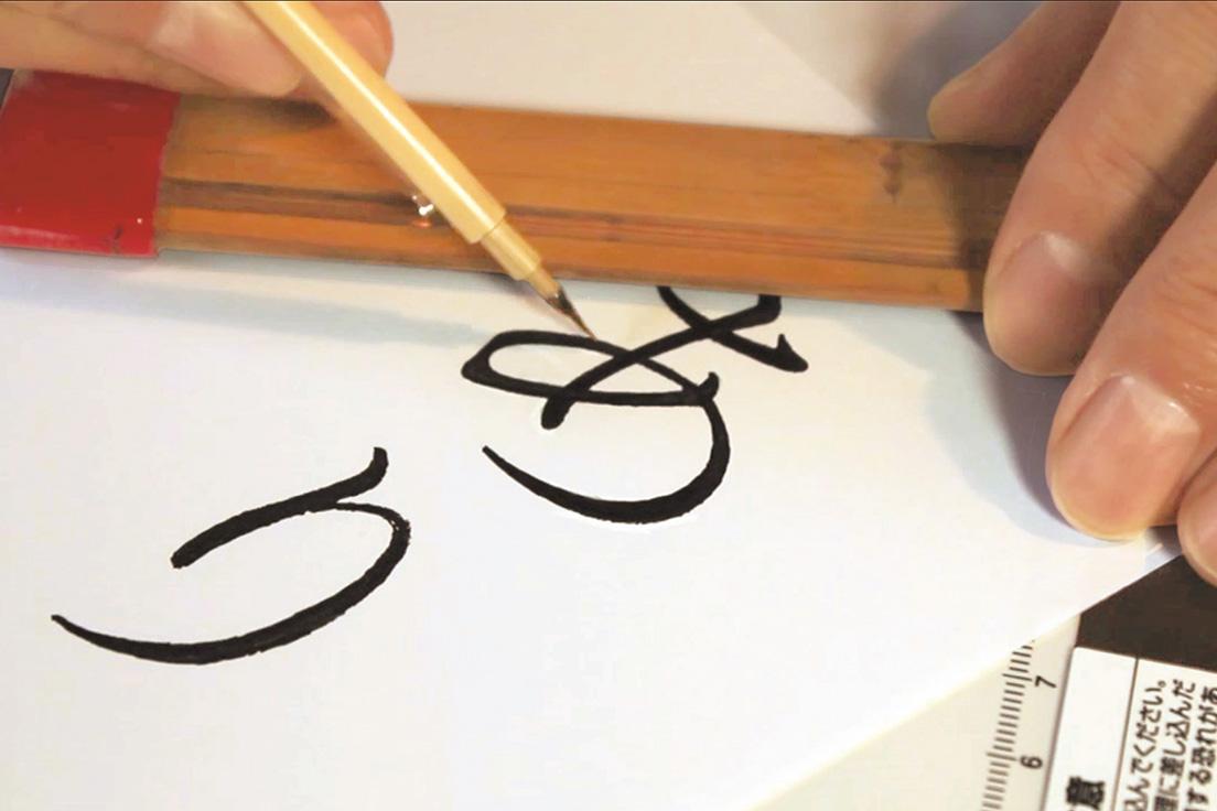 書体作りの最終段階では人の手で微調整。極細の筆（品印）を使って線の太さやカーブを整えていく。