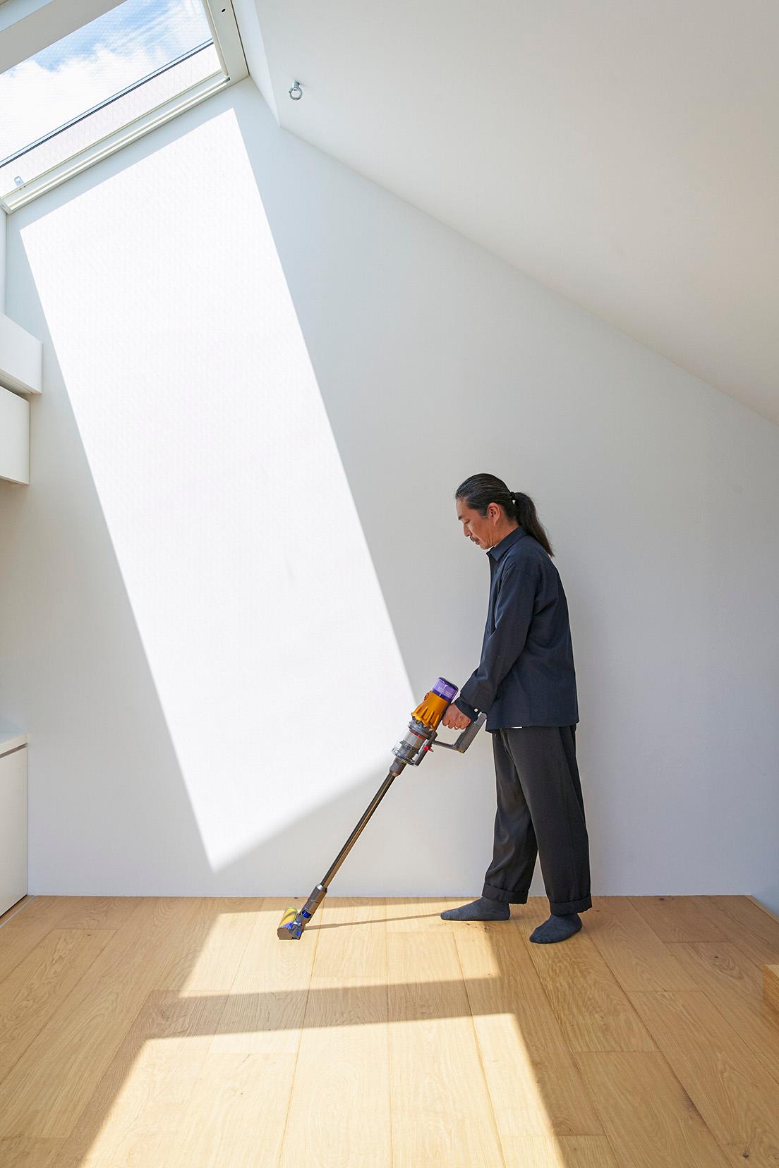 3階の書斎を掃除中の君塚賢さん。今回は新たに“グリーンレーザー”が搭載されたことで話題の新型の《Dyson V12 Detect Slim》で、自ら設計した自邸を掃除する。