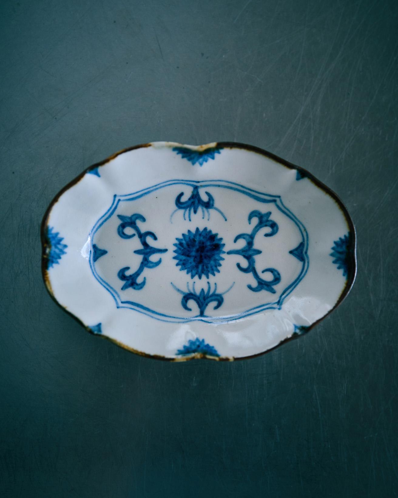 陶芸家・須藤拓也さんの豆皿。皮鯨（口縁部に濃い色の縁取りをあしらうこと）の縁の皿は盛った料理が締まって見えて、使い勝手がいいです。こちらは何年か前に青い絵付けが好きで購入しました。絵があってもかわいすぎないところが気に入っています。