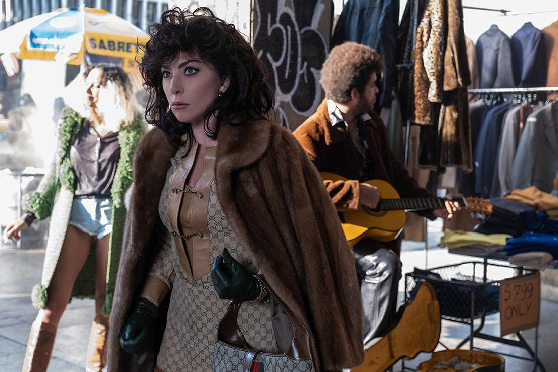 グッチ家を狂わせた女性、パリツィアを演じるレディ・ガガ。ヴィンテージのダブルGドレスとバッグが80年代のムードを伝える。
