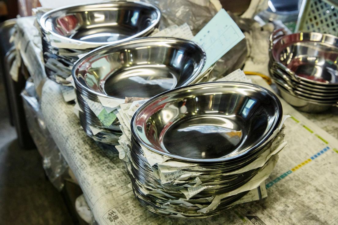 昭和43年に業務用として作り始めたステンレスのカレー皿。懐かしさも感じる個性的な形は、スタッキング可能。
