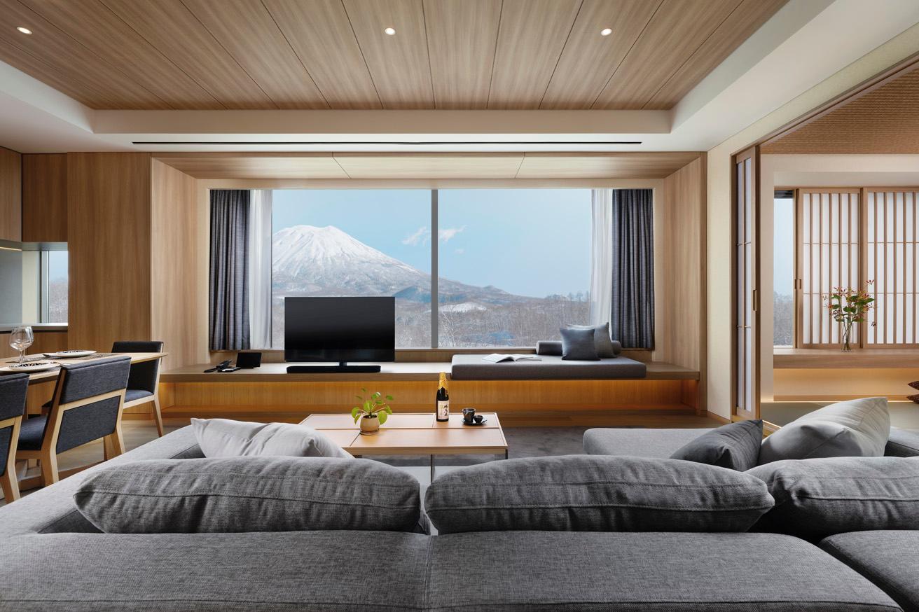 2ベッドルームスイートのリビングルーム。大きく開いた窓からは北海道の雄大な自然が見える。