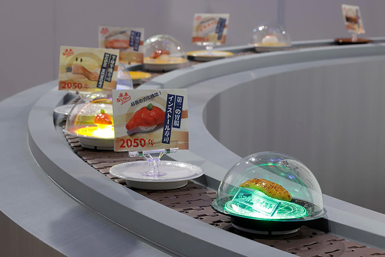 市原えつこ《未来SUSHI》（部分）2022年。とても食べられるとは思えない寿司が回っているディストピア寿司店。