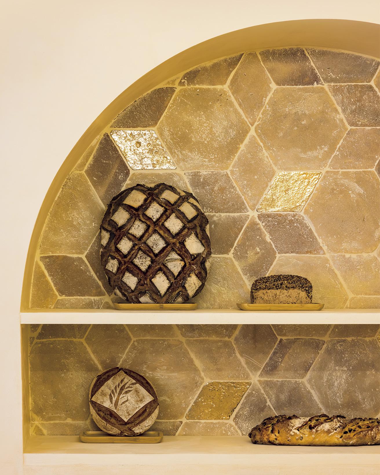 アーチ型陳列棚の内側は石灰や金箔で表面加工したテラコッタタイル。