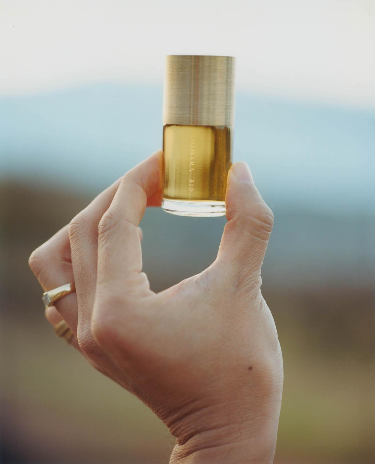 ガラスのボトルに真鍮のキャップのボトルデザインが、ミニマルな〈シハラ〉のジュエリーと呼応する。