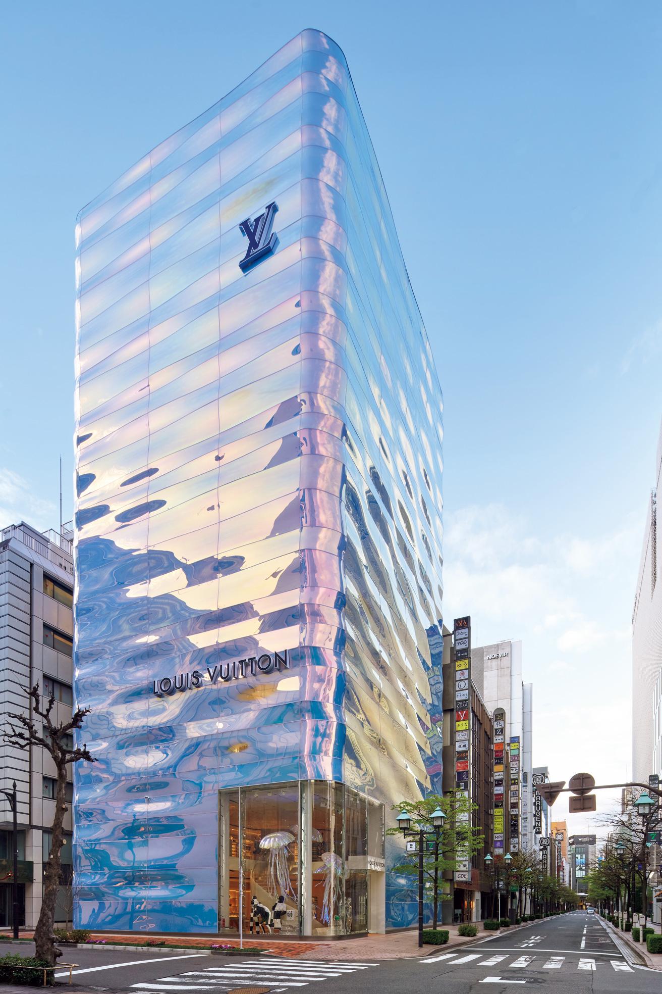 TOKYO〈銀座並木通り店〉by 青木 淳　青木淳の設計によって、2021年にオープンしたストアのイメージは “水の柱” 。2層の曲面ガラスを使用したファサードは、空や銀座の街並みの色を複雑に反射し、時間や角度、天候によってその見え方が異なる。水をモチーフとしたのは、かつて、銀座が東京湾に突き出した半島の先端だったことから。東京都中央区銀座7-6-1。(c) Louis Vuitton/Daici Ano