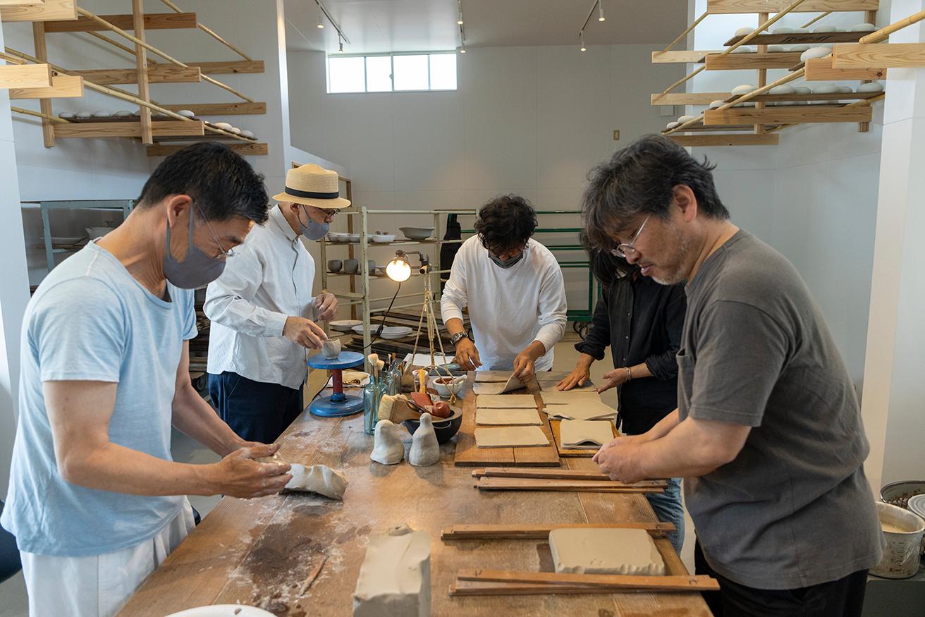 撮影日、たまたま遊びにきていた木工作家・三谷龍二さんも一緒に制作（左奥）。