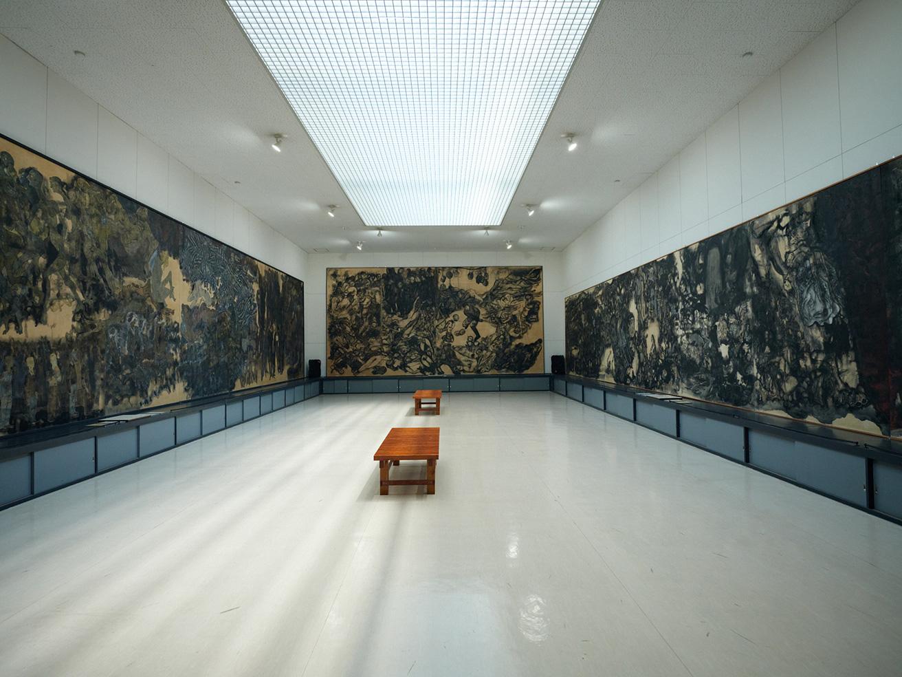 〈原爆の図　丸木美術館〉の展示室。奥に見えるのは《南京大虐殺の図》、左は《アウシュビッツの図》、右は《水俣の図》。丸木夫妻は原爆だけでなく、弱者にふるわれるさまざまな暴力に目を向けた。