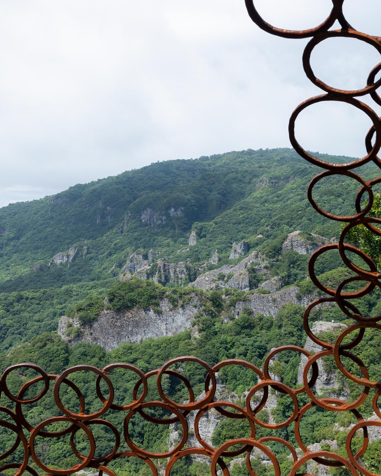 青木野枝《空の玉／寒霞渓》から見える光景。ごつごつした岩と丸い鉄の彫刻が対比を見せる。