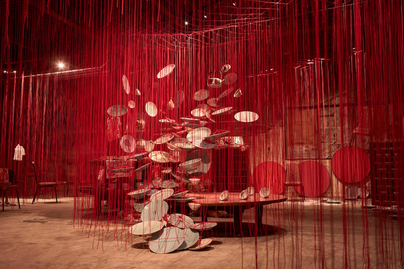 《巡る記憶 ― 中華園》。皿、椅子、テーブルなど店にあったものが赤い糸でつながれている。