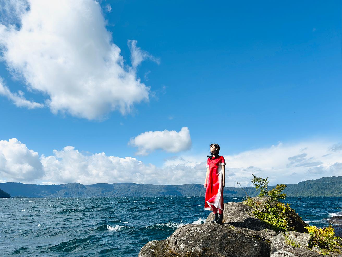 ■1倍メインカメラ 24mm 48MP　紺碧の湖面に白い雲と波が映える十和田湖畔。周囲の原生林からは鳥のさえずりが聞こえる。なだらかな稜線も美しい。転写プリントドレス344,300円（ロエベ／ロエベ ジャパン クライアントサービス TEL 03 6215 6116）。他はスタイリスト私物。
