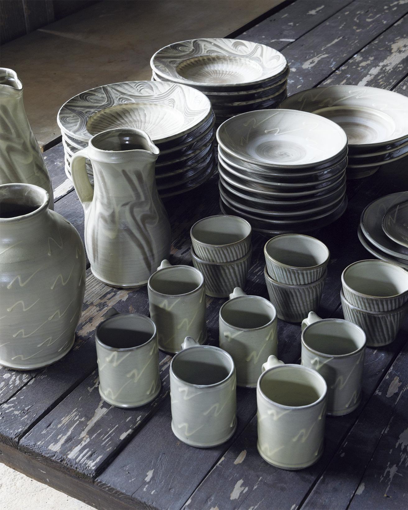 10月13日から販売されるコラボレーションアイテムの一部。マグや皿とともにピッチャーや花器の姿も。グレーの釉薬と抽象的に描かれたNの形が特徴に。
