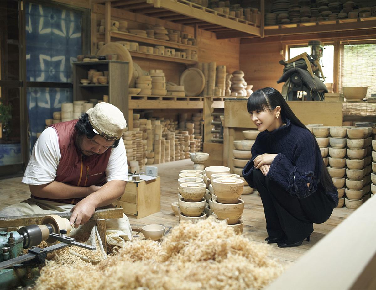 Amid stacks of chestnut bowl bases, in the studio of Ikkei Ninjō, who crafts the bowls on a woodworking wheel. “It’s set low,” KASHIYUKA observes. “Considering the preciousness of the wood, it’s best to keep it that low,” replies the artisan.