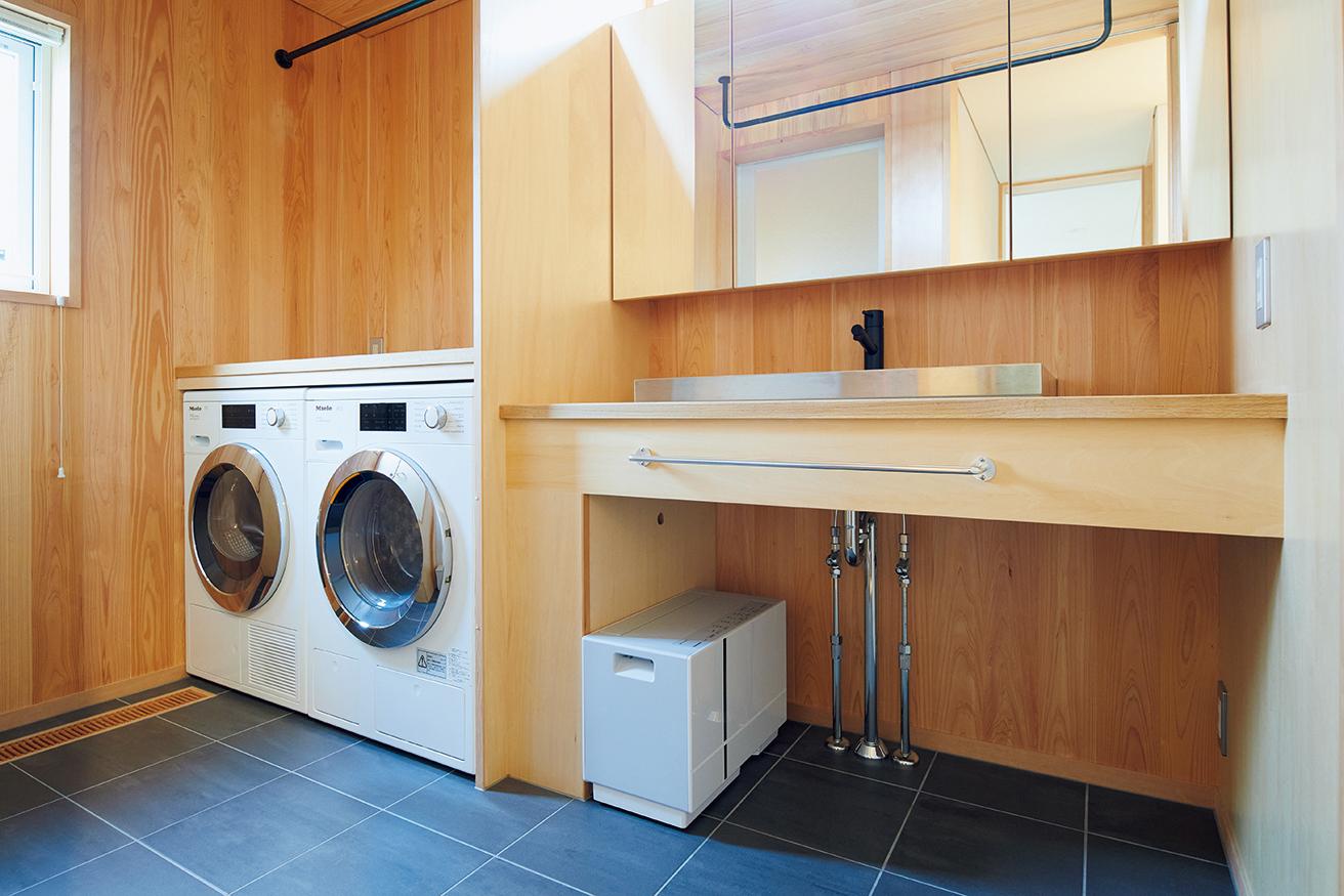 1階の洗面所には洗濯機と電気式乾燥機、部屋干し用の除湿機が並ぶ。