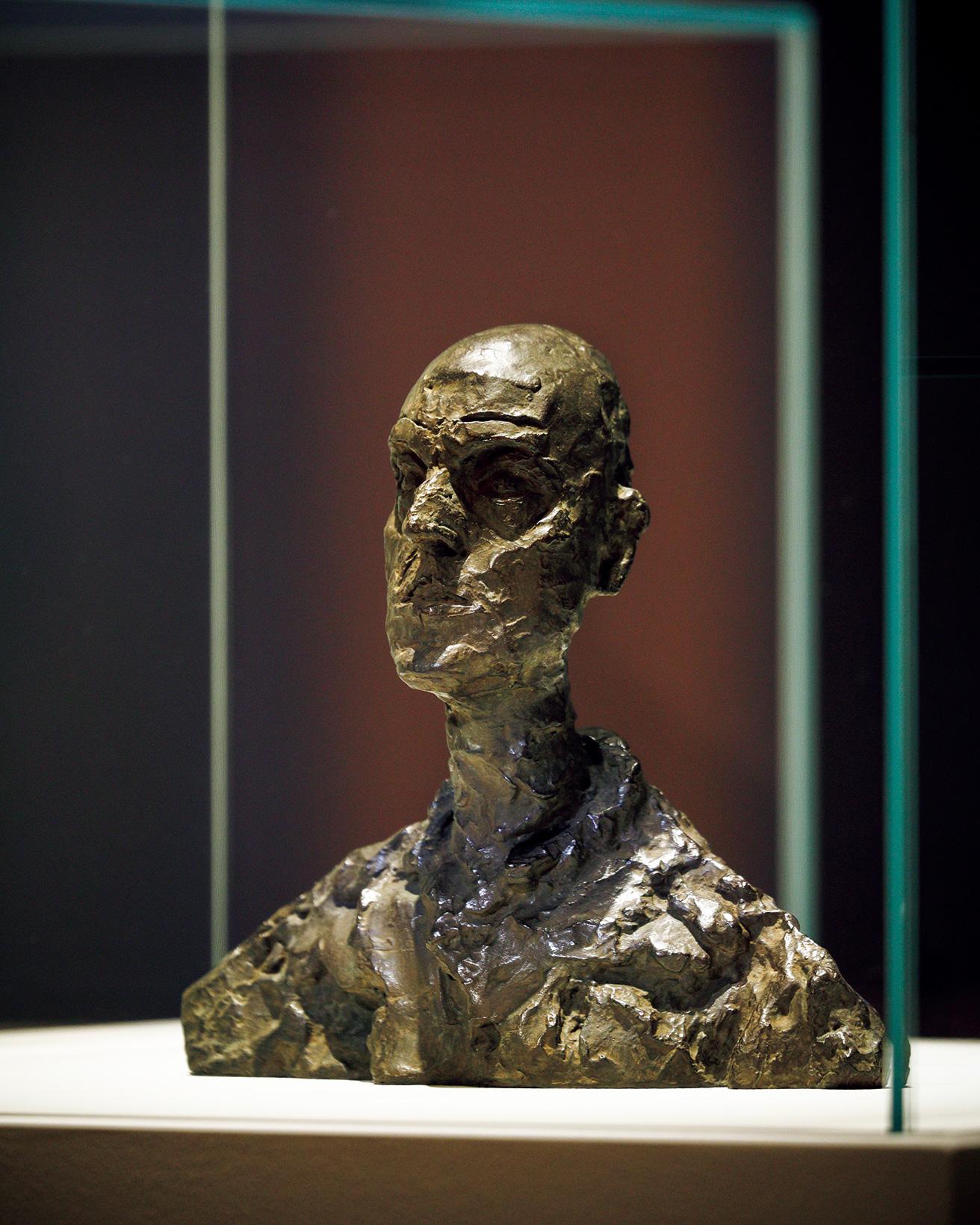 《男の頭部（ロタールⅠ）》（1964-65年）。ルーマニア出身の前衛写真家エリ・ロタールは、ジャコメッティ最後の彫刻作品のモデルとなり、3つの作品となった。《男の頭部（ロタールⅠ）》は頭部と肩のみからなる、もっとも小さな作品。凝縮したサイズで触覚に訴える作品からは、正面切った自信が感じられる。