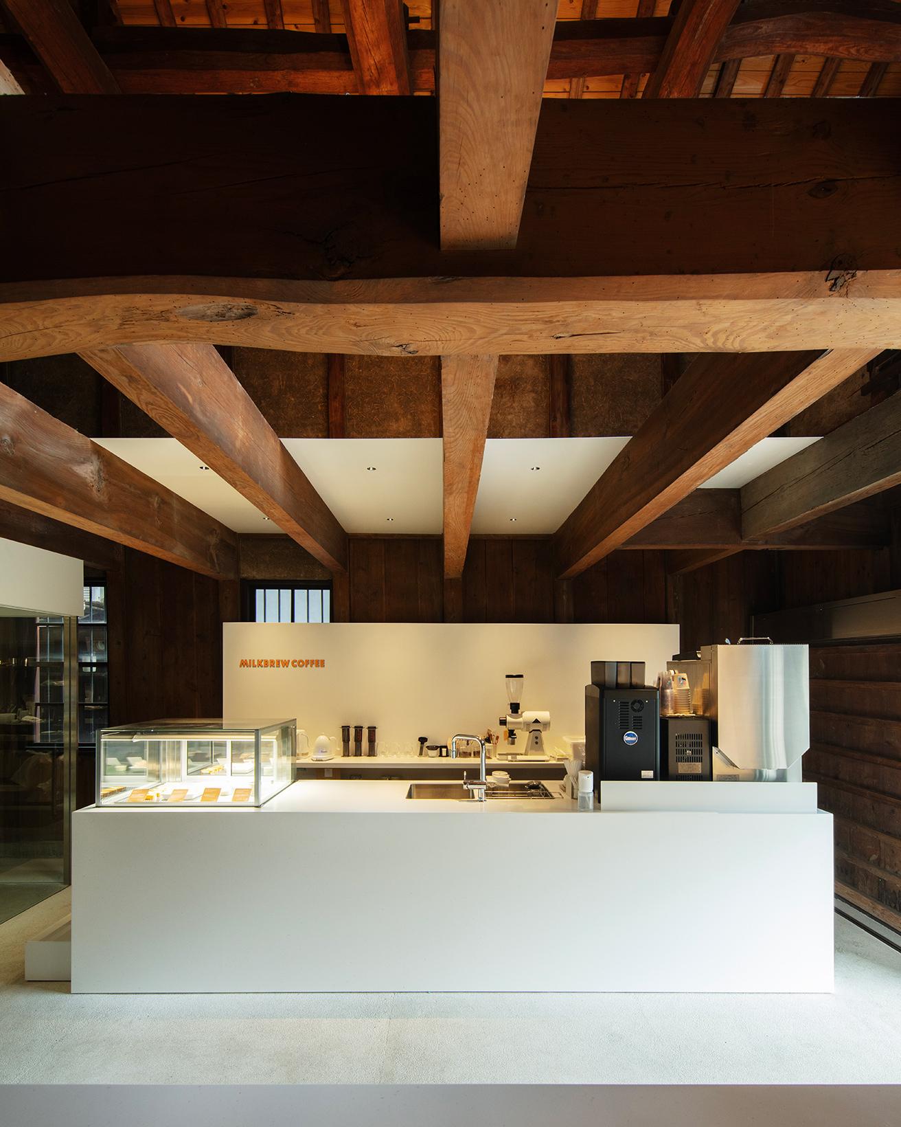 蔵の太い梁と人造大理石のカフェカウンターが心地よいコントラストを生む。