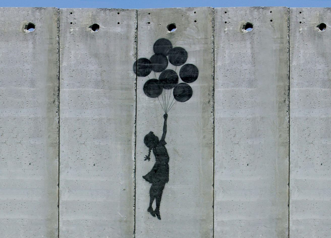 シュレッダー事件でお馴染みの《風船と少女》がモチーフ。オリジナルは少女が風船を手放している構図だが、2005年にパレスチナの分離壁に描いた際は、少女がたくさんの風船に掴まって壁を乗り越える姿へと改変された。photo_Aflo