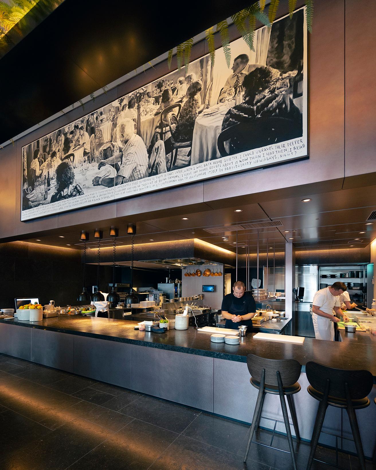 広々としたオープンキッチンのカウンターの上には、ハーマンシェフが一番のお気に入りだというアートが飾られている。人々がレストランで幸せな時間を過ごしているシーンを描いたこの絵は、ハーマンシェフが求める理想のレストランを象徴している。