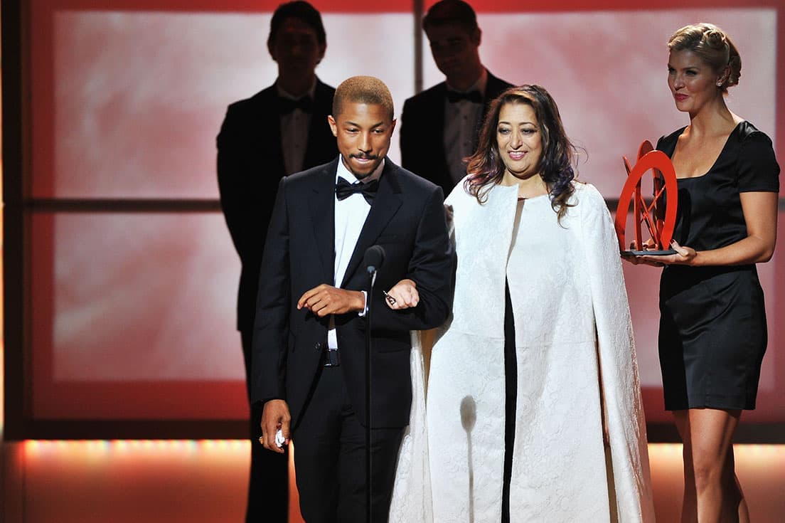 2012年のグラマー誌の「今年の女性」の授賞式で、ファレル・ウィリアムスと腕を組んで登場したザハ・ハディド。 photo _Theo Wargo / WireImage for Glamour Magazine