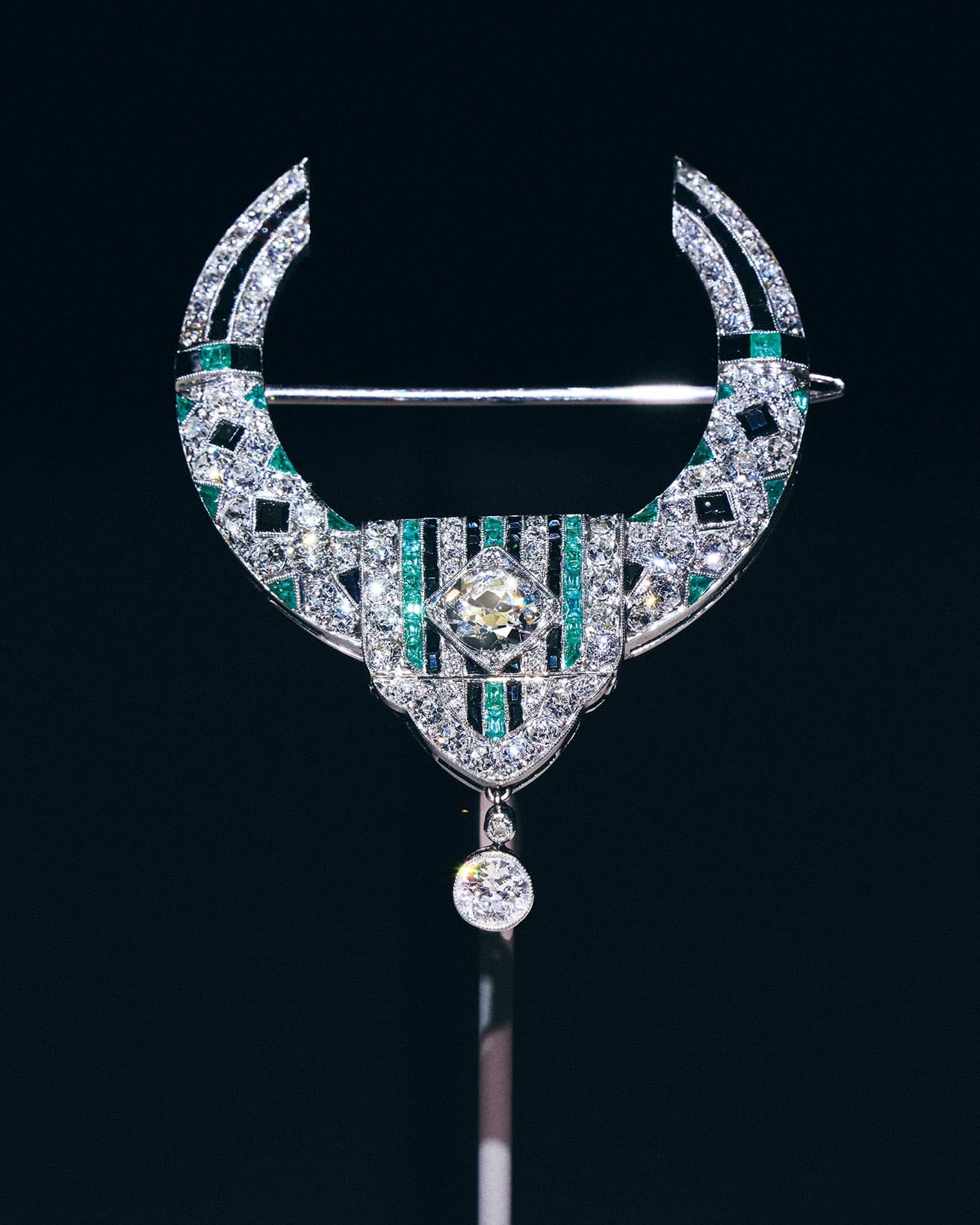 《ループ ブローチ》1919年、プラチナ、エメラルド、オニキス、ダイヤモンド。〈ヴァン クリーフ&アーペル〉の歴史においてアール・デコ様式の萌芽といえる作品。扉や窓を縁取る布製の垂れ飾りの形状を反映させたデザイン。