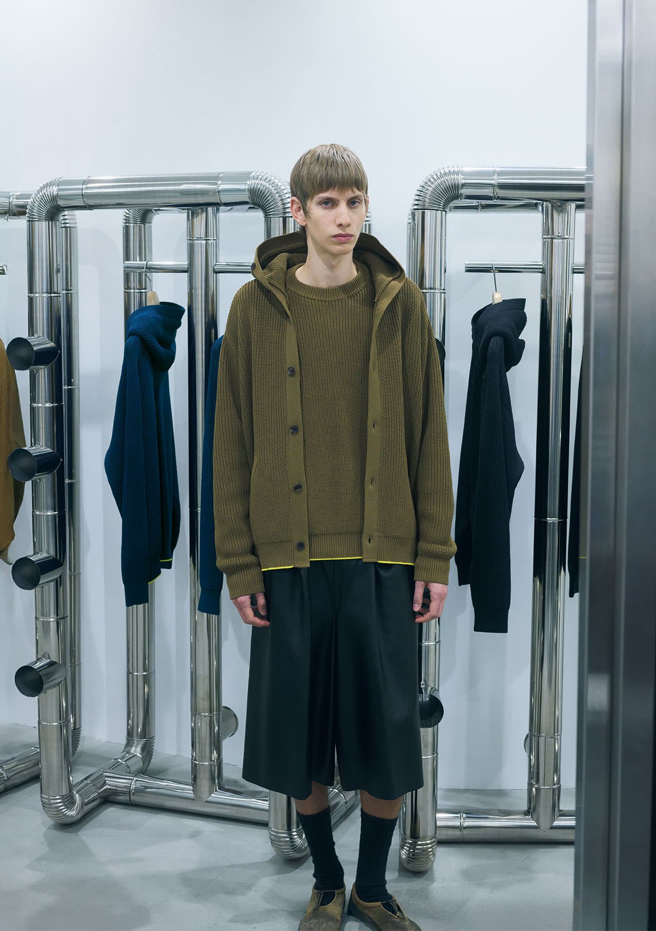 ニットオンニットのスタイリング。ニットフーディ8万1950円、セーター5万5000円、シューズ2万2000円(以上東京デザインスタジオ ニューバランス/ニューバランス お客様相談室 TEL 0120 85 7120)。レザーショーツ17万6000円(リバーバレイト/レショップ青山 TEL 03 5413 4714)。ソックスはスタイリスト私物。