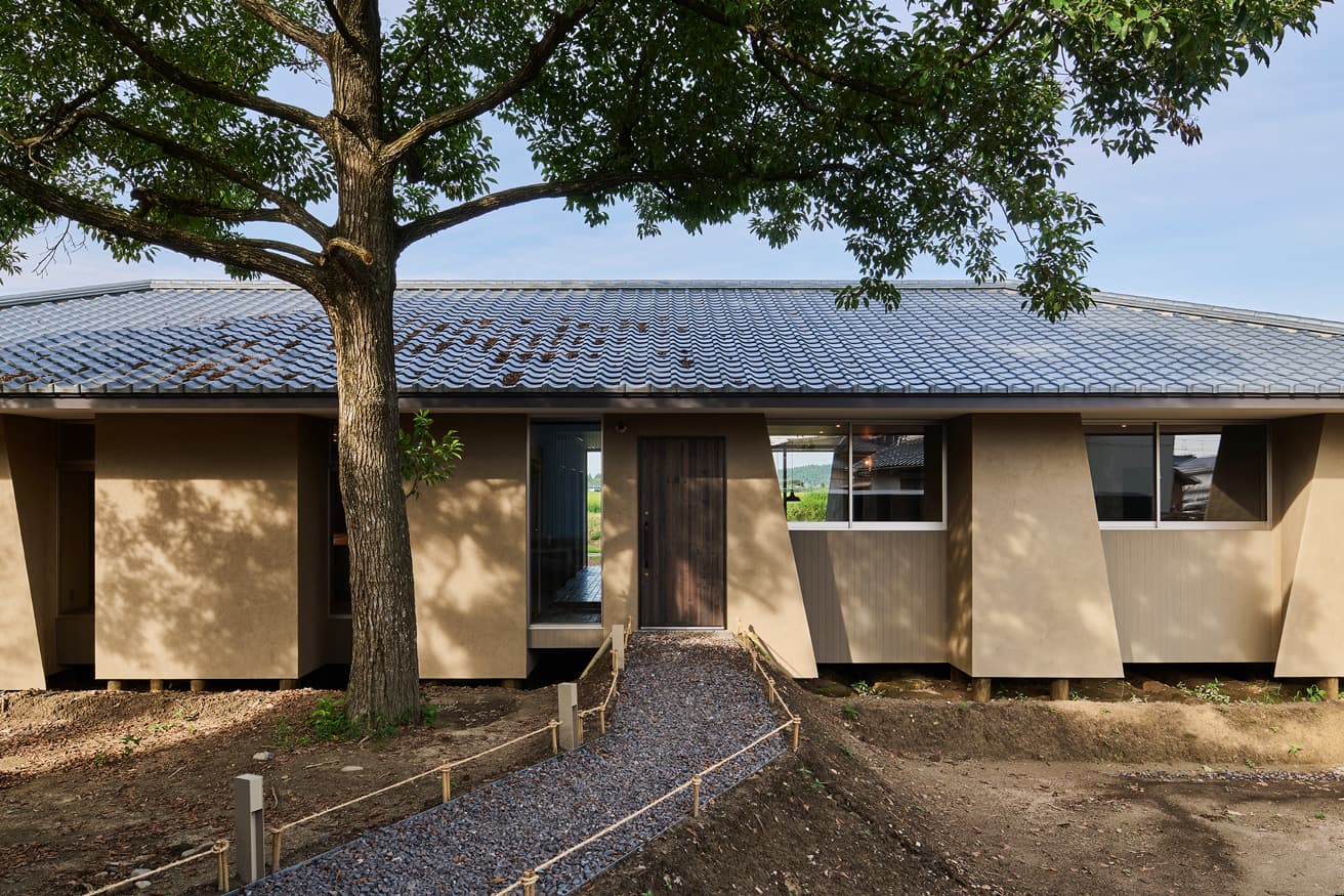 建物東側のエントランスへと続くアプローチ。砂利のように見える足元には、実際に使用された安田瓦を砕いた瓦チップスが敷き詰められている。