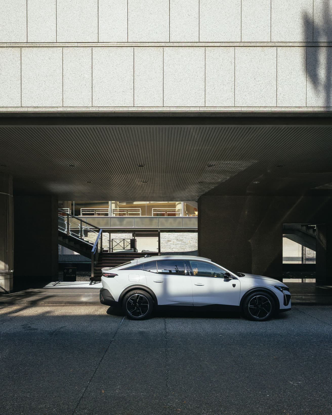 〈新国立劇場〉の車寄せに到着した《プジョー408》。直線的な建築美と対照的に、伸びやかなラインを描く。*車寄せへの留置は特別な許可を得て撮影しています。
