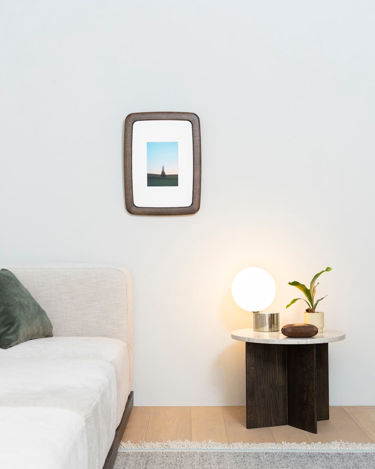 空間の中で柔らかな存在感をたたえる《frame ROUND by karimoku》。サイドテーブル《N-ST01 Side Table(Small)》249,700円(カリモク家具 TEL 0562 83 1111)、クッションカバー《BRUSHED》5,280円、テーブル上のボックス ZANAT《GENKANボックス》127,600円(アクタス青山店 TEL 03 5771 3591)、マイケル・アナスタシアデス《TIP OF THE TONGUE》テーブルライト430,100円(YAMAGIWA東京ショールーム TEL 03 6741 5800)。